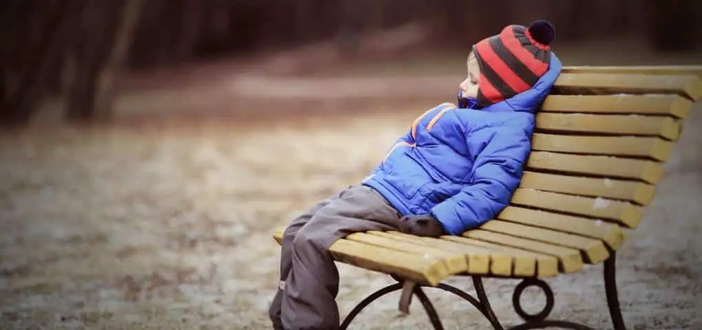 sad kid sitting on bench