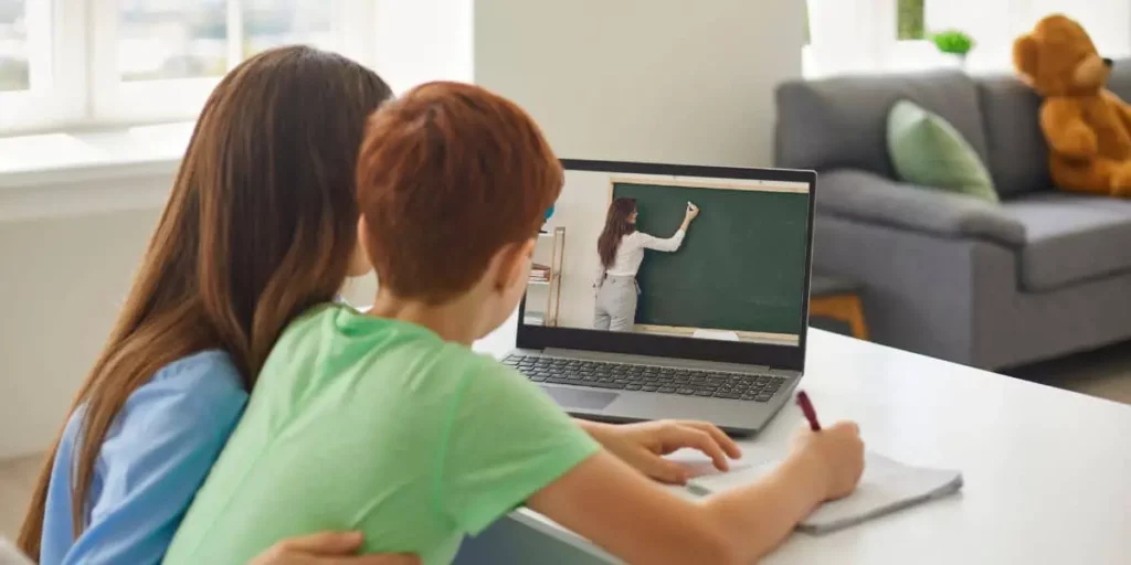 mom guiding son in online class