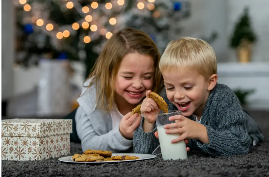 A girl and boy sharing jokes for kids with one plate of cookies