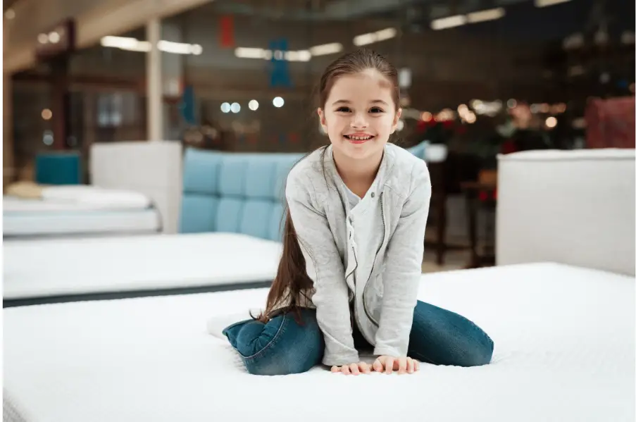 smiling girl seated on a mattress