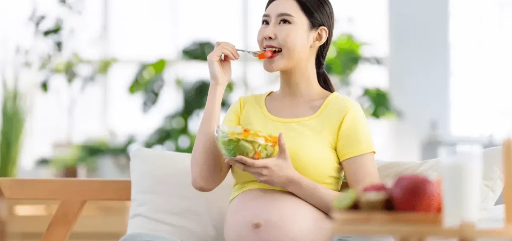 pregnant woman eating fresh vegetables